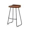 A counter height bar stool with a walnut wood saddle seat and a black metal frame.